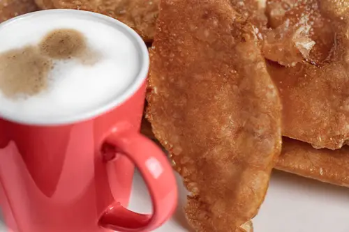 Buñuelos con una bebida caliente