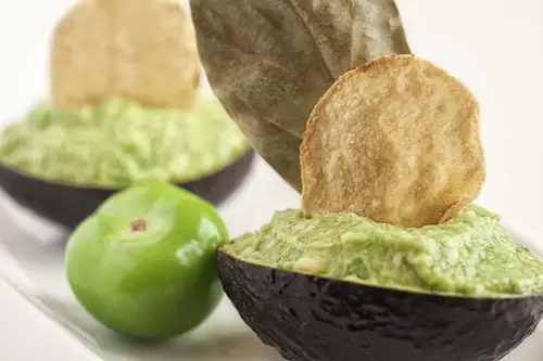 Tomatillo Guacamole presented with a tortilla chip
