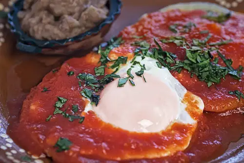 Huevos Rancheros servidos con frijoles refritos