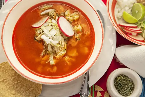 Pozole Rojo de Pollo acompañado con muchos ingredientes