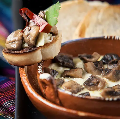 Melted Cheese with Mushrooms in a clay cazuela