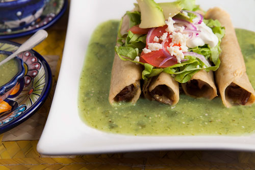 Fried Beef Tacos over green salsa