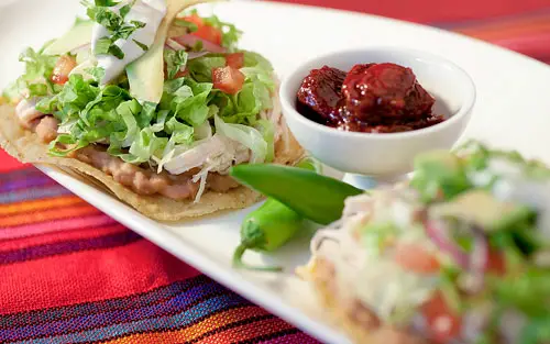 2 Tostadas de Pollo sobre un mantel Mexicano